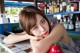 A woman leaning on a counter in front of a bar.