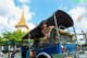 A woman sitting in the back of a blue tuk tuk.