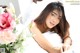 A woman laying in bed next to a bouquet of flowers.