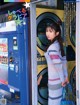 A woman standing in front of a vending machine.