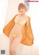 A woman in a yellow lingerie posing for a picture.