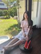 A woman sitting on a porch with a plate of watermelon.