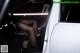 A woman sitting in the driver's seat of a white car.