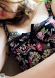 A woman wearing a black and pink floral lingerie.