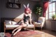 A woman in a bunny suit sitting on a couch.