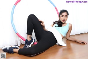 A woman laying on the floor with a hula hoop.